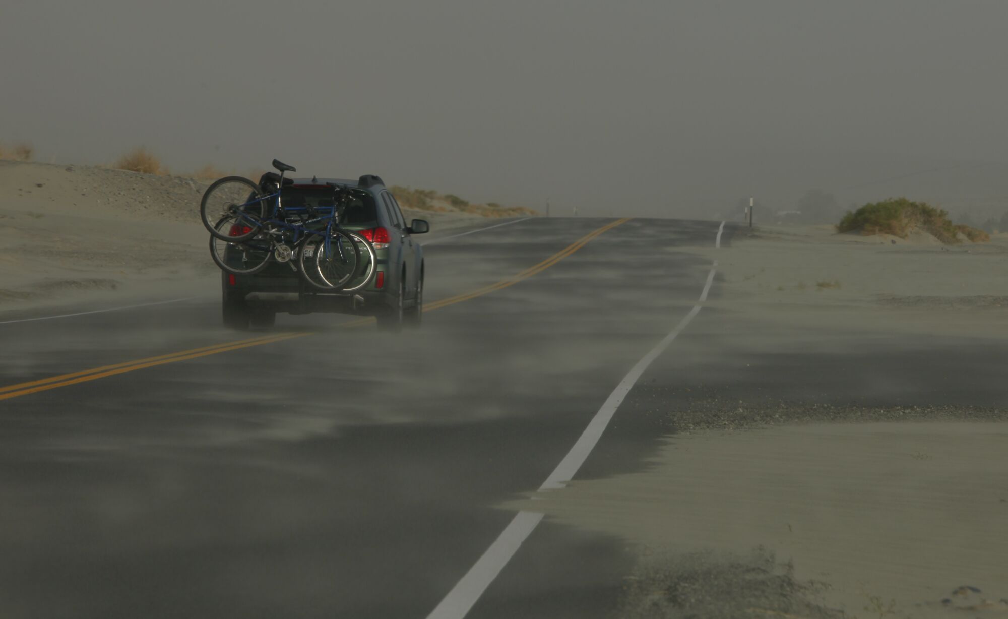 The road along old Highway 136 bound for Keeler, California, is blocked by drifting dust.