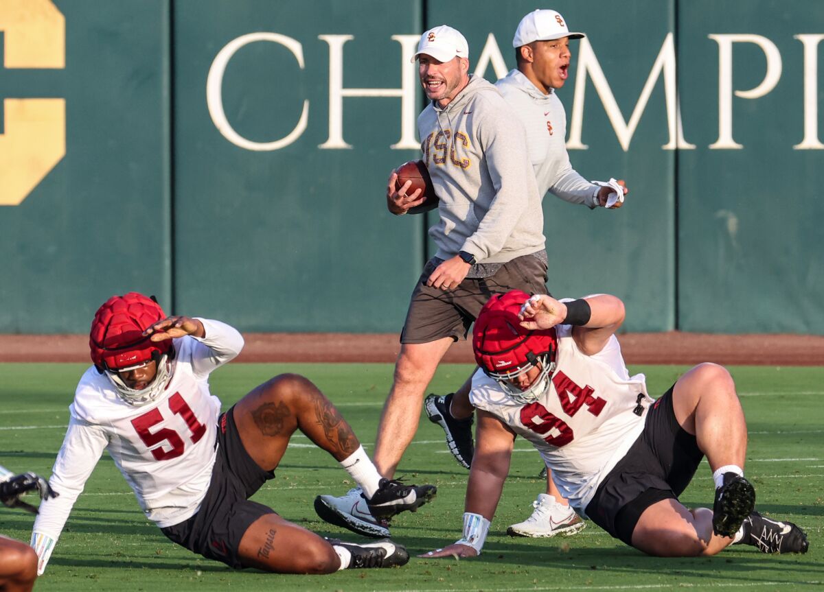 USC defensive coordinator Alex Grinch and defensive passing game coordinator Donte Williams bark out instructions to players.
