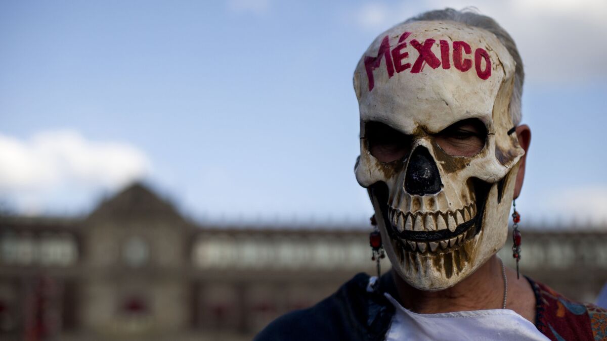 The calavera — or skull — is a common motif in Mexican folk art and it is employed frequently in the Aytozinapa protests. A woman clad in a skull mask stands in front of the National Palace during a rally in the Zocalo, the capital's main square.