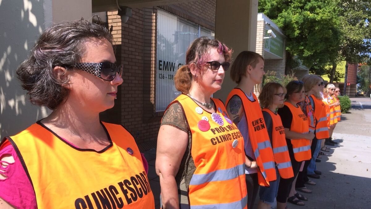 Volunteer escorts line up outside EMW Women's Surgical Center in Louisville, Ky., to protect access to the facility during an anti-abortion protest in July.