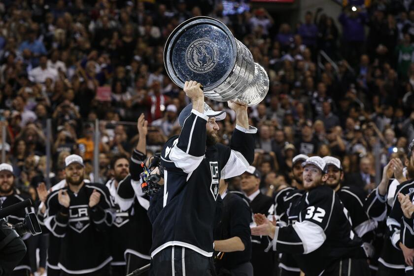 Defenseman Robyn Regehr holds the Stanley Cup above his head after the Kings' double-overtime victory over the New York Rangers that clinched the NHL championship in 2014.