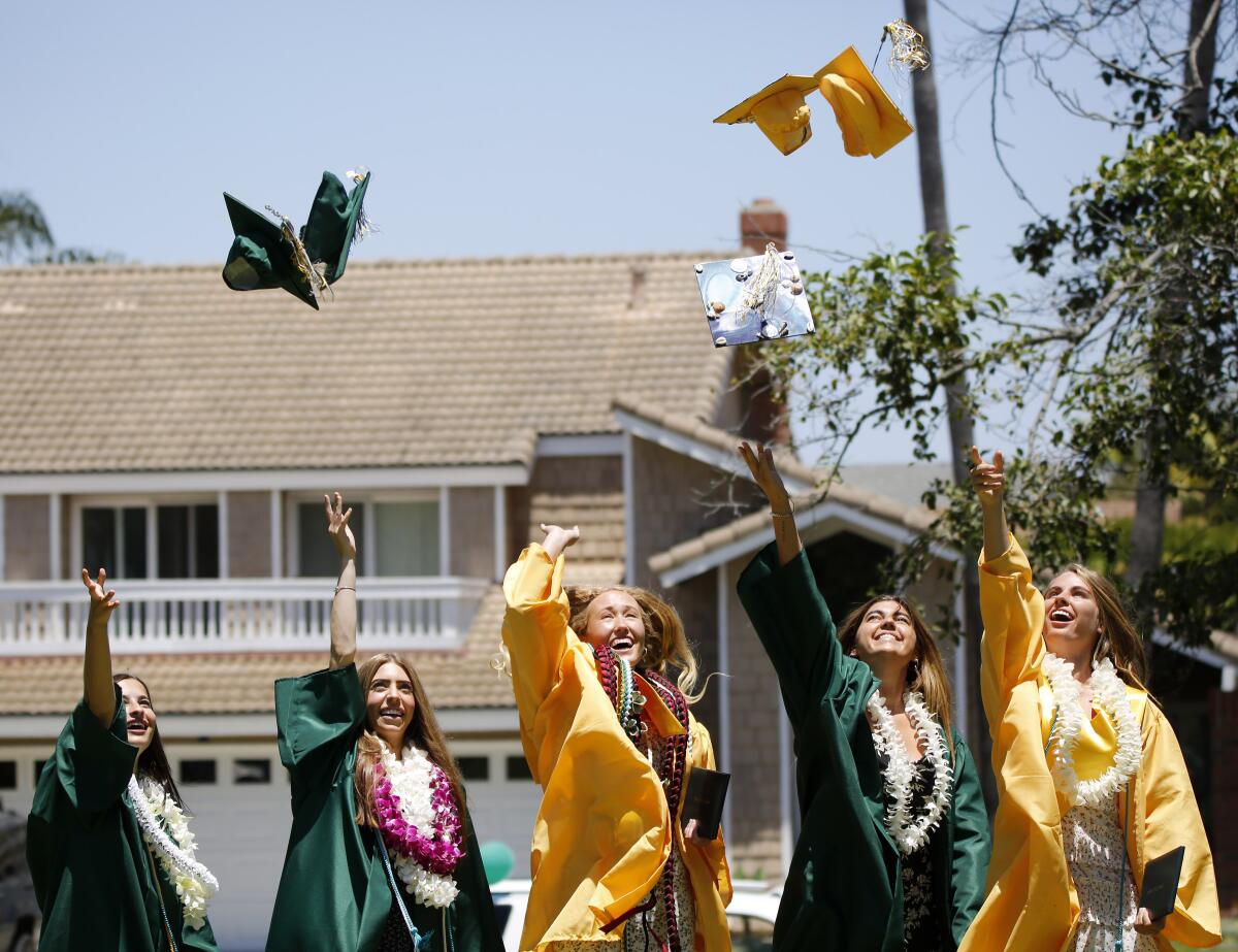 A group of graduates tosses their caps into the air for a photo after receiving their diploma from Edison High.