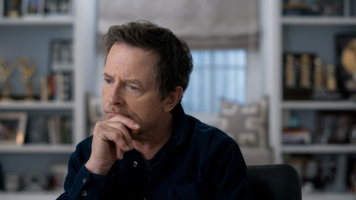 Michael J. Fox rests his chin in his hand in "Still: A Michael J. Fox Movie."