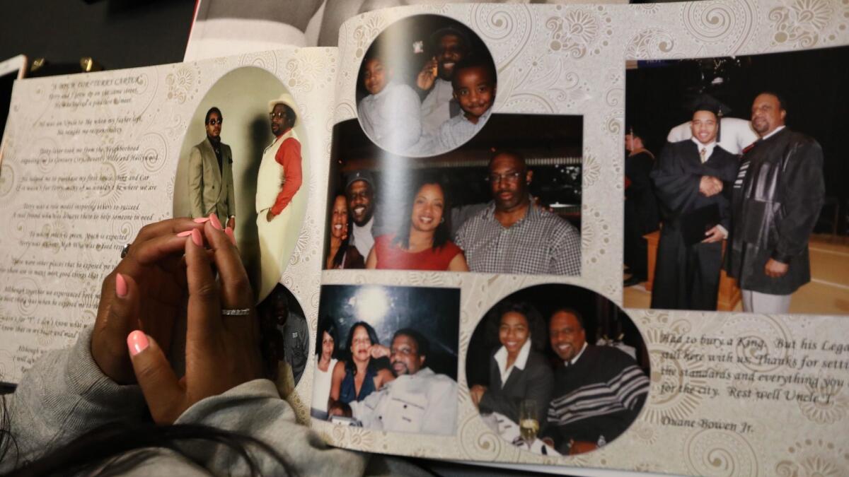 Crystal Carter looks over a book that features photos of her father, Terry Carter, with family and friends in Marina del Rey.