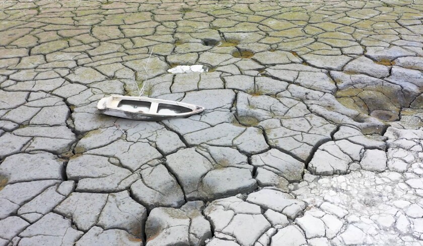In this photo released by Nantou County Government, a boat is stranded on a dried lakebed in Sun Moon Lake in Nantou county in central Taiwan on April 23, 2021. Some households in Taiwan are going without running water two days a week after a months-long drought dried up the island's reservoirs and a popular tourist lake. (Nantou County Government via AP)