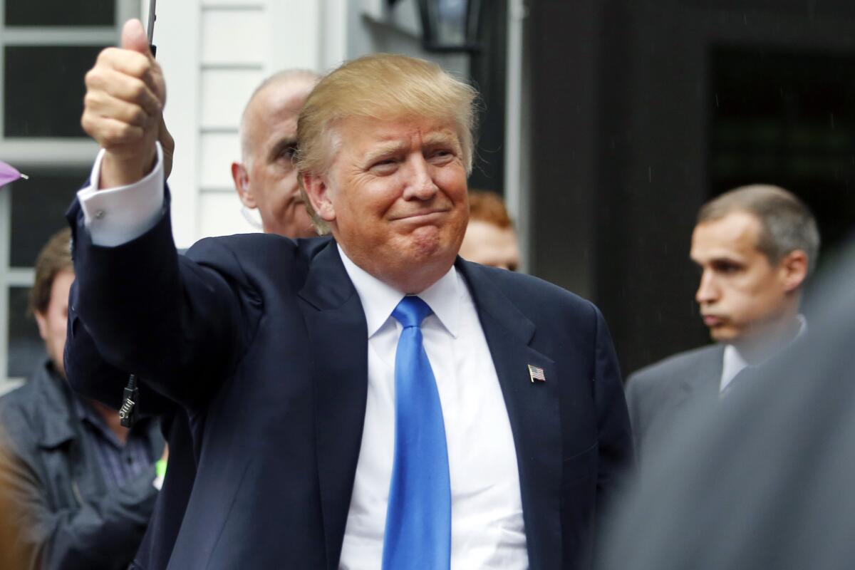 Republican presidential candidate Donald Trump waves as he arrives at a house party June 30 in Bedford, N.H.