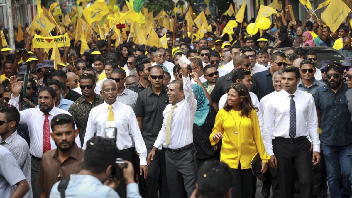 Former President Mohamed Nasheed, center, waves during a rally in Male, Maldives, celebrating his return from exile. President-elect Ibrahim Mohamed Solih is on his right.
