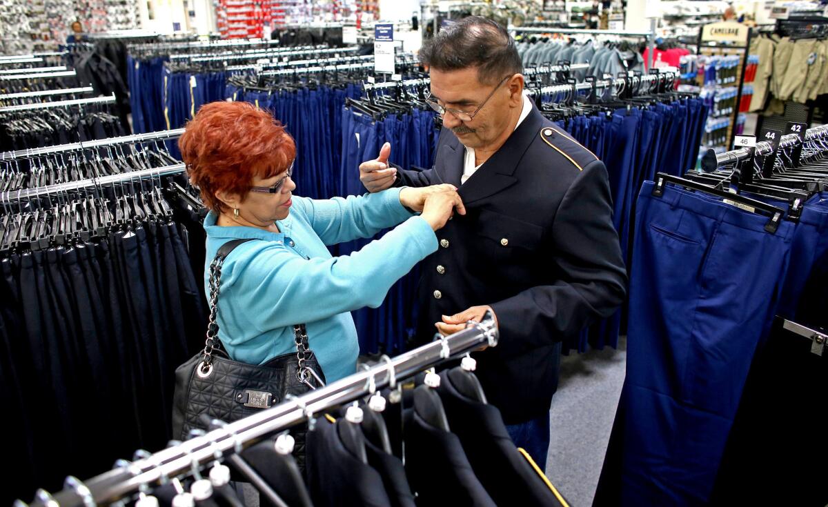 At a military store in San Antonio, Erevia's wife, Leticia, helps him pick out a uniform for his Medal of Honor ceremony at the White House on March 18.