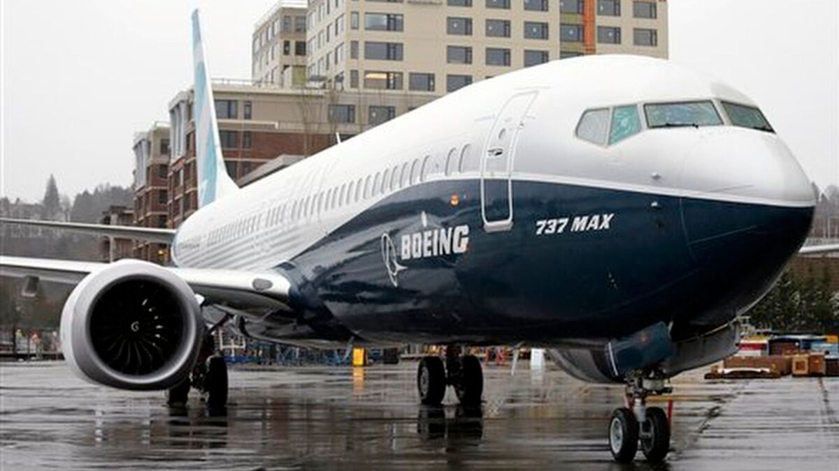 A new Boeing commercial airplane rolls past its production plant in Renton, Wash.