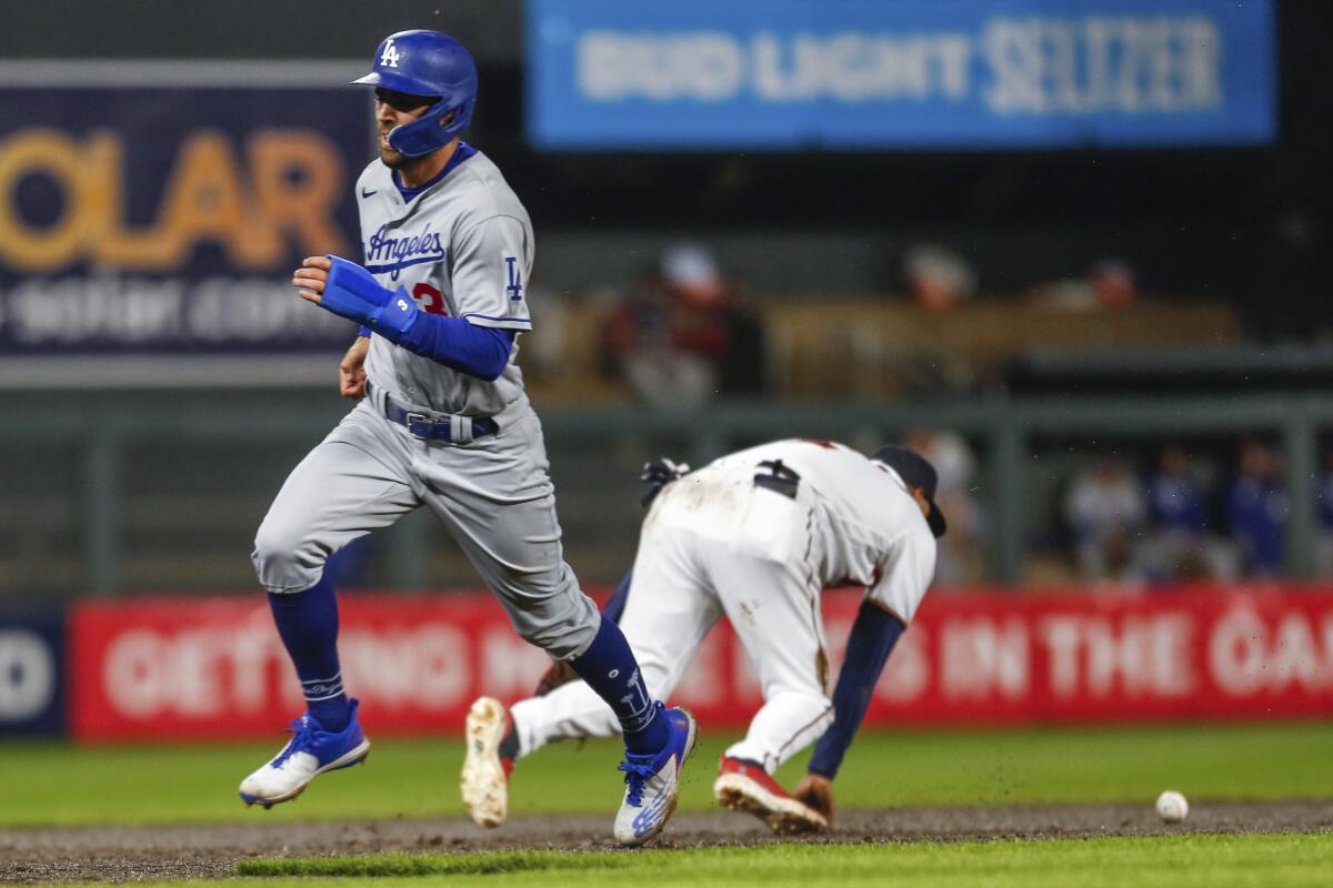 Dodgers' Chris Taylor advances to third as Minnesota Twins third baseman Luis Arraez tries to field a single.