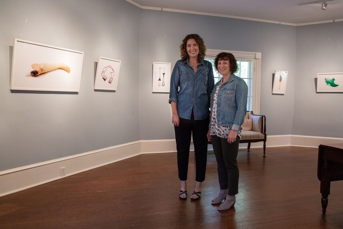 Jody Servon, left, and Lorene Delany-Ullman, right, pose for a photograph with the exhibit at the Horace Williams House in Chapel Hill, N.C. in October 2017.