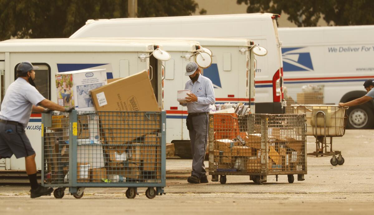Mail carriers load their trucks at a post office in Van Nuys