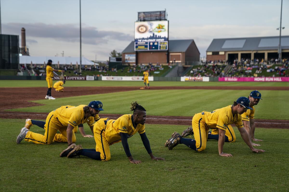 Savannah Bananas first base coach Maceo Harrison dances with players during a game.