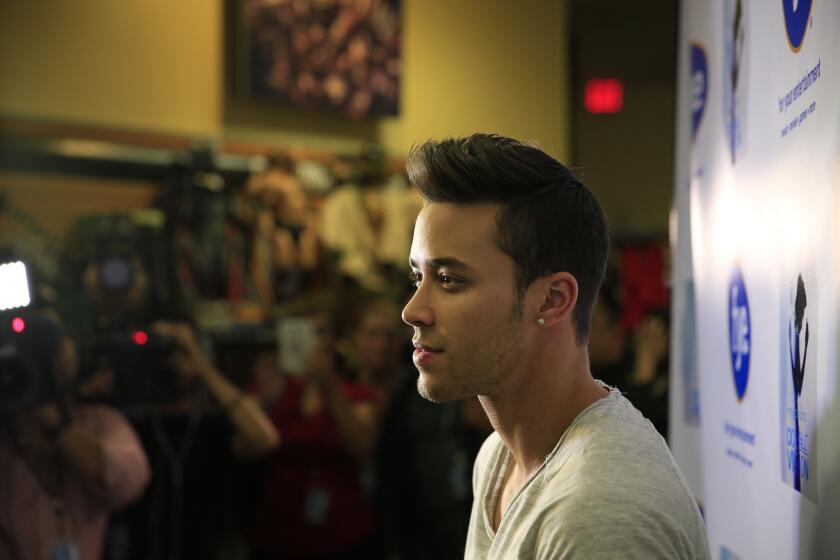 Prince Royce, the bachata star with a new English-language pop album, poses for cameras during an appearance last month at a record store in Fullerton.