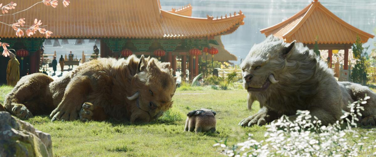two large lions flank a small furry winged creature