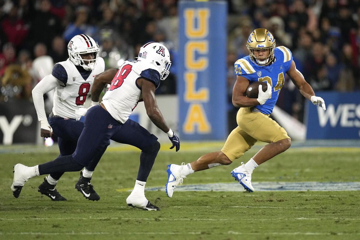 UCLA running back Zach Charbonnet avoids Arizona linebackers Sterling Lane II and Jerry Roberts.