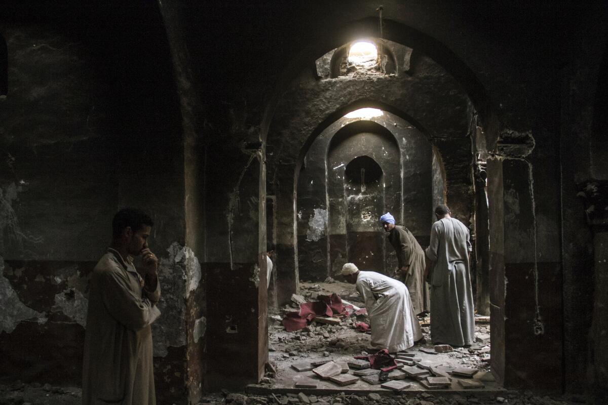 Egyptian Christian villagers clean up after Islamists looted and burned the chapel inside the Virgin Mary and St. Abraam Monastery in Dalga.
