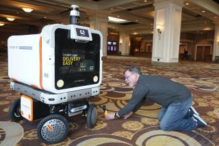 A member of the media films the Ottobot Yeti as it operates before the start of the CES tech show, Wednesday, Jan. 4, 2023, in Las Vegas. Ottonoy.IO launches Ottobot Yeti at CES 2023. Ottobot Yeti, is a fully autonomous delivery robot that can navigate unattended deliveries for food and beverage retail and curbside deliveries. (AP Photo/Rick Bowmer)
