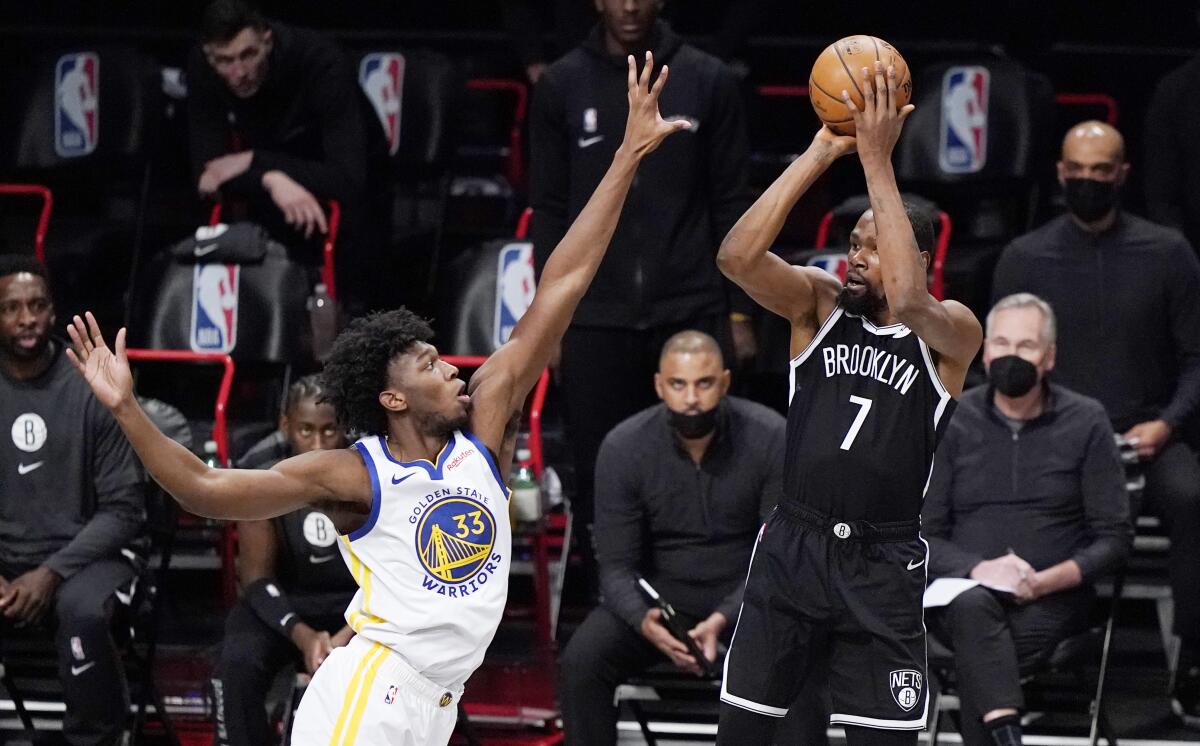 Golden State Warriors center James Wiseman defends as Brooklyn Nets forward Kevin Durant looks to shoot.