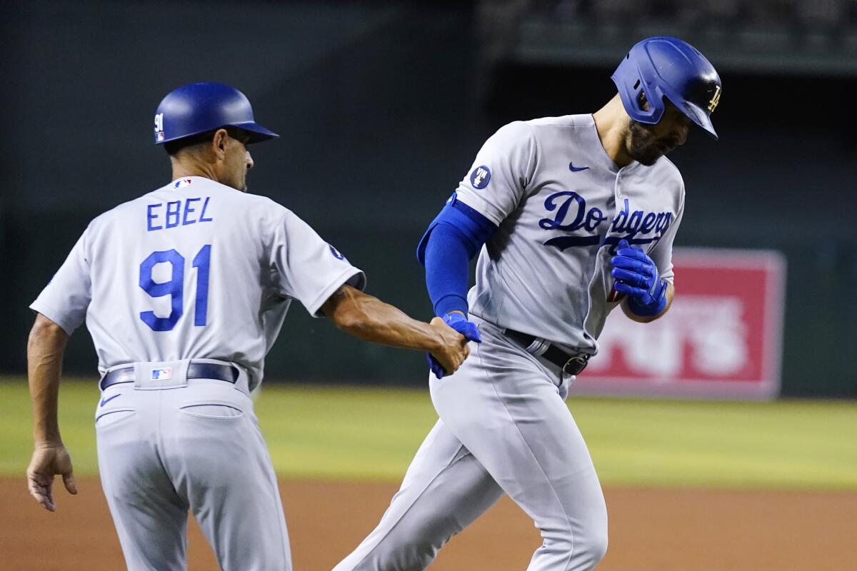 Dodgers' Joey Gallo shakes hands with third base coach Dino Ebel.