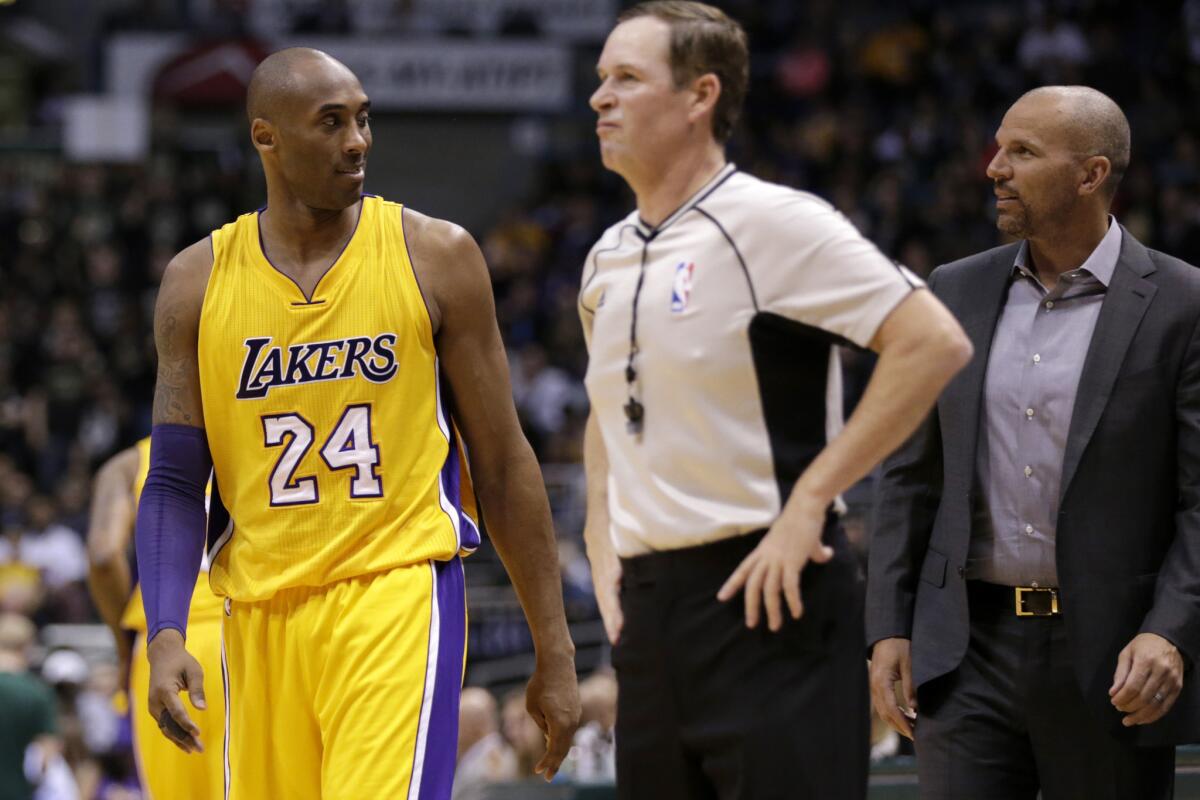 Lakers forward Kobe Bryant smiles at Bucks Coach Jason Kidd as he walks onto the court during the second quarter.
