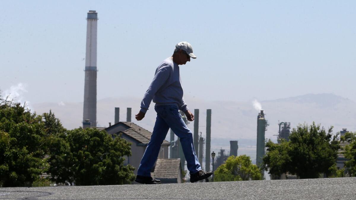A pedestrian walks in front of the Valero Benicia Refinery in Benicia, Calif. on July 12.
