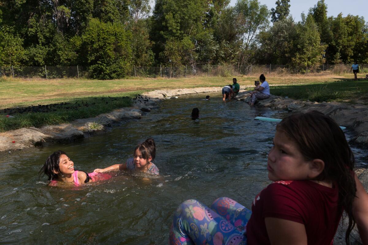 Girls play in a stream near Lake Balboa at Anthony C. Beilenson Park in Van Nuys on Sunday.