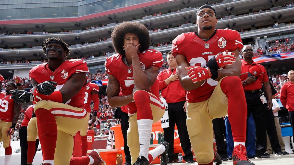 Colin Kaepernick, center, takes a knee during the national anthem before a 2016 game. Many NFL players followed his lead in 2017.
