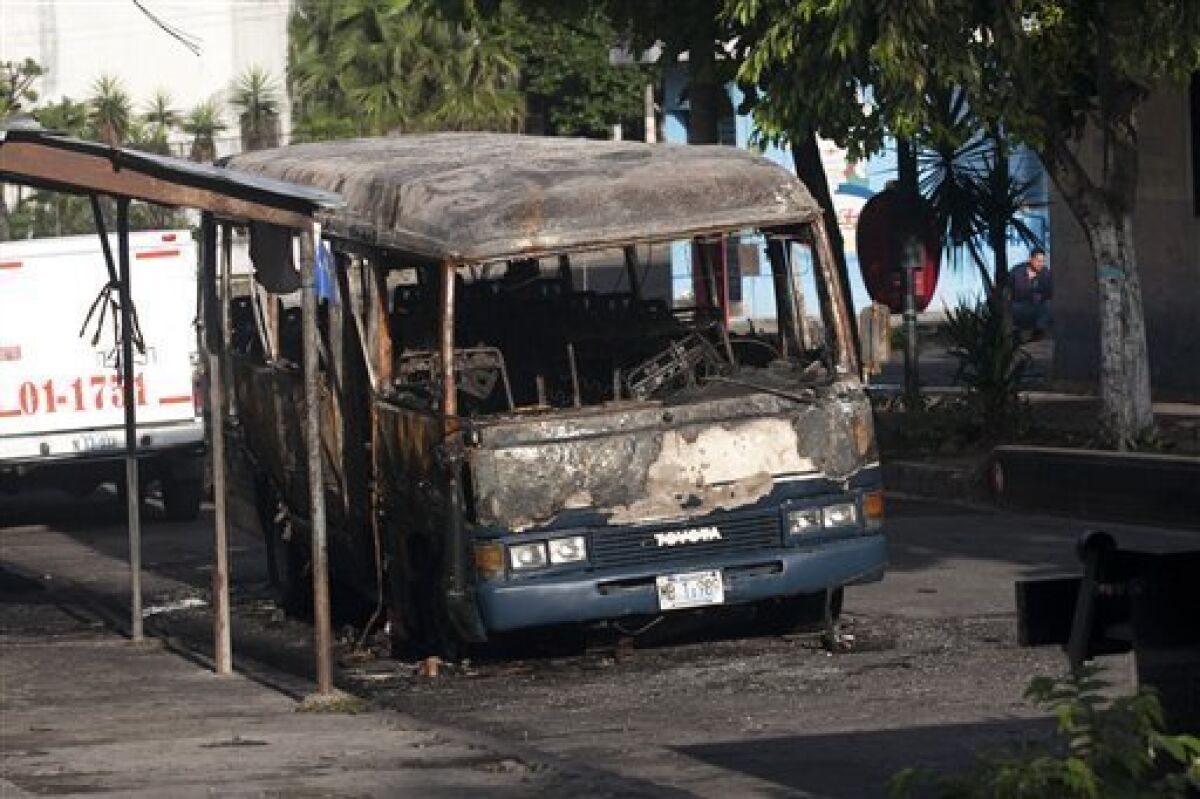 A burnt bus sits at a street in San Salvador, Monday, June 21, 2010. The bus was attacked Sunday night while driving along its regular route in the northern area of San Salvador, killing at least 10 people who were aboard and leaving several others badly hurt. (AP Photo/Edgar Romero)