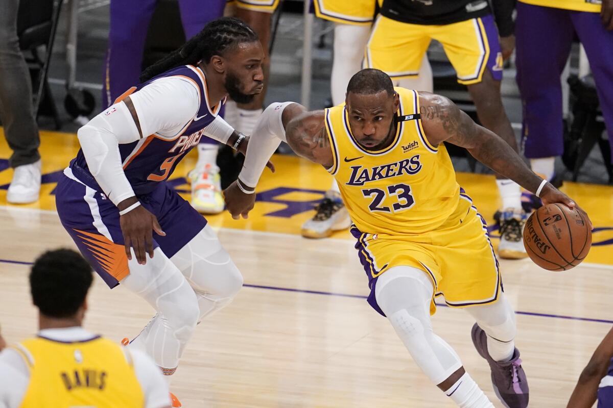 Los Angeles Lakers forward LeBron James (23) is guarded by Phoenix Suns' Jae Crowder 