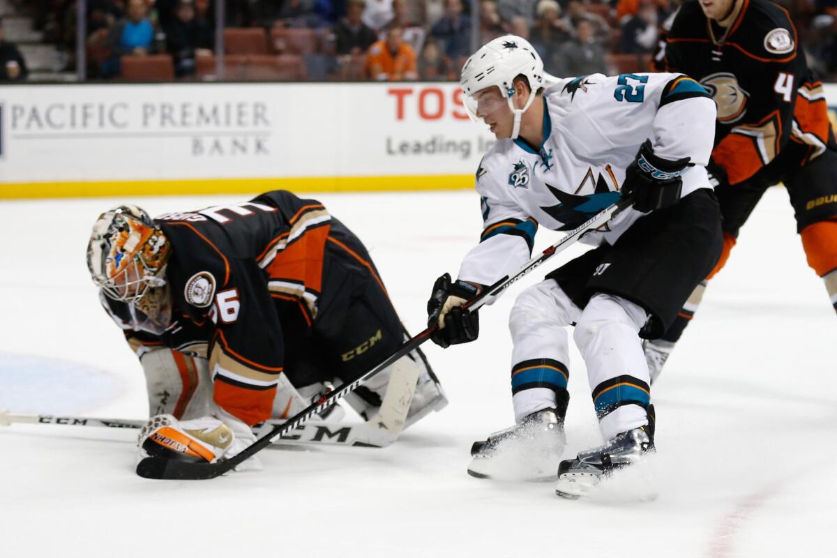 Ducks goalie John Gibson covers the puck under pressure from San Jose forward Joonas Donskoi during the second period of a game on Dec. 4.