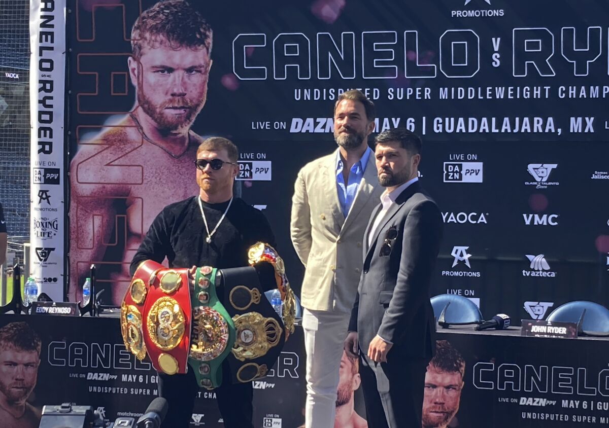 Canelo Alvarez sostiene su colección de cinturones de campeón de peso medio frente al retador John Ryder 