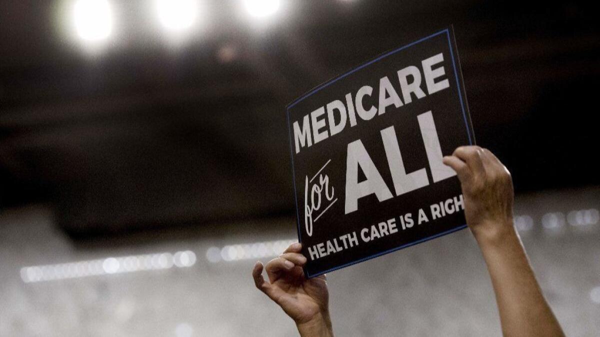 A member of the audience holds up a placard as Sen. Bernie Sanders discusses "Medicare for all" legislation on Capitol Hill on Sept. 13, 2017.