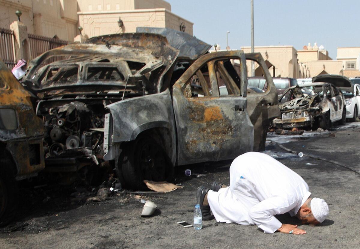 A victim's relative prays at the site of a suicide bombing that targeted a Shiite Muslim mosque in the Saudi city of Dammam.