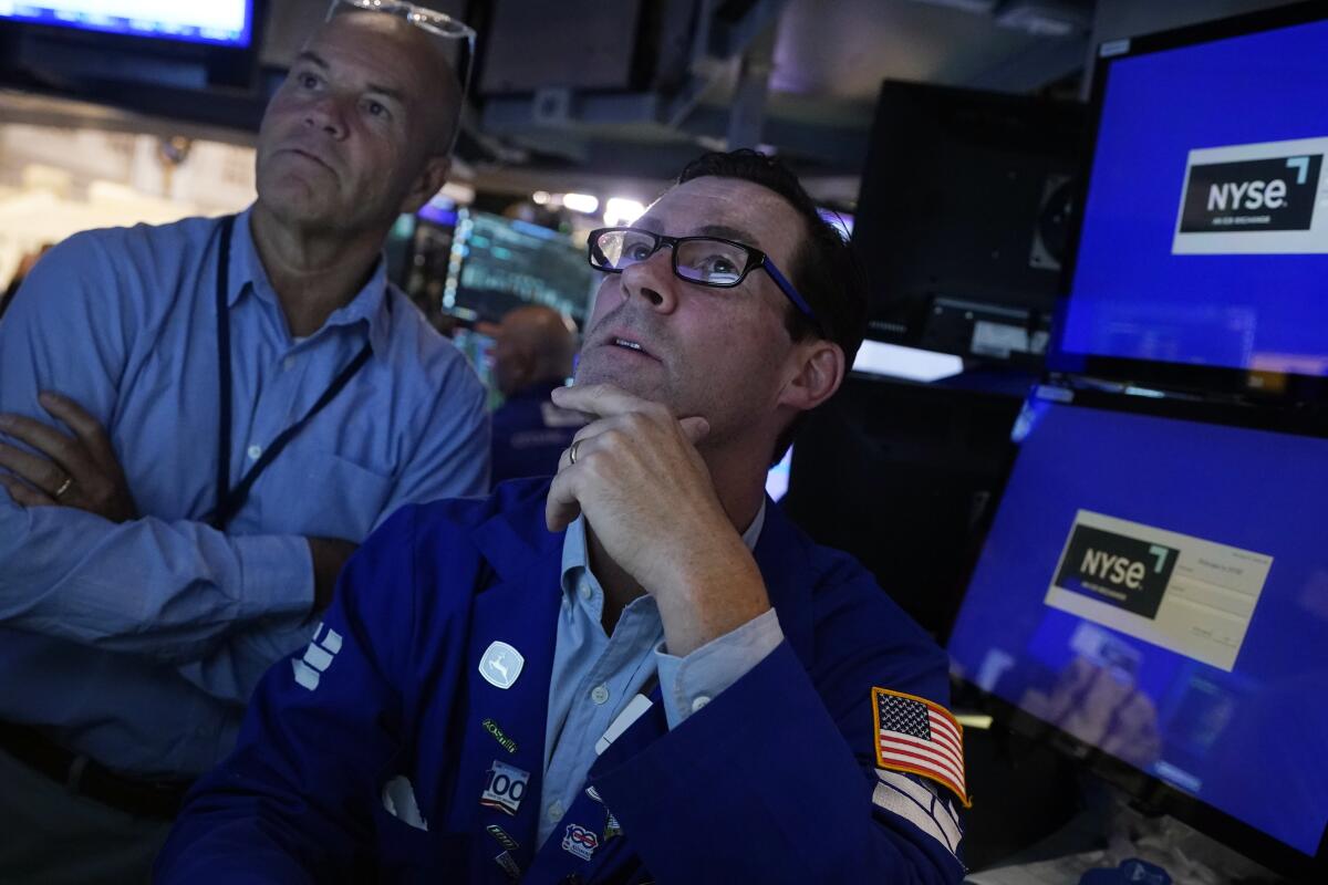 Two men next to monitors.