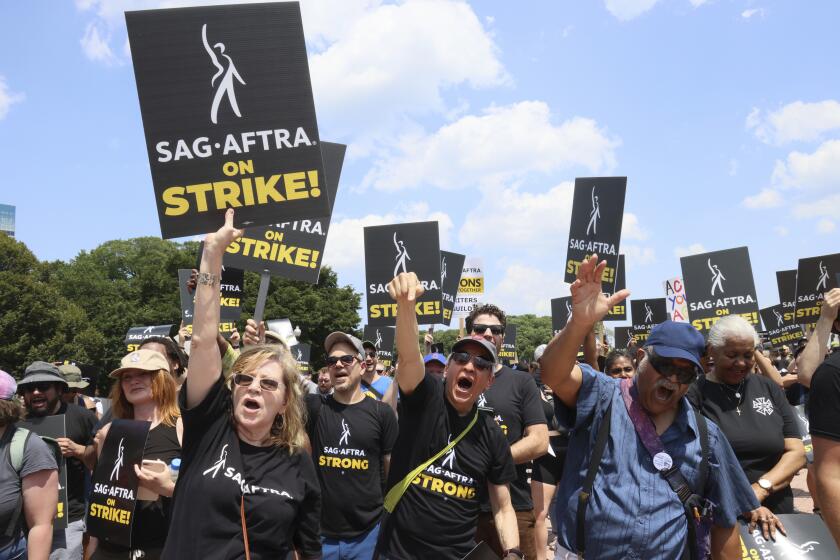 Guionistas y actores en huelga sostienen letreros durante una protesta en Chicago, el jueves 20 de julio de 2023. (AP Foto/Teresa Crawford)