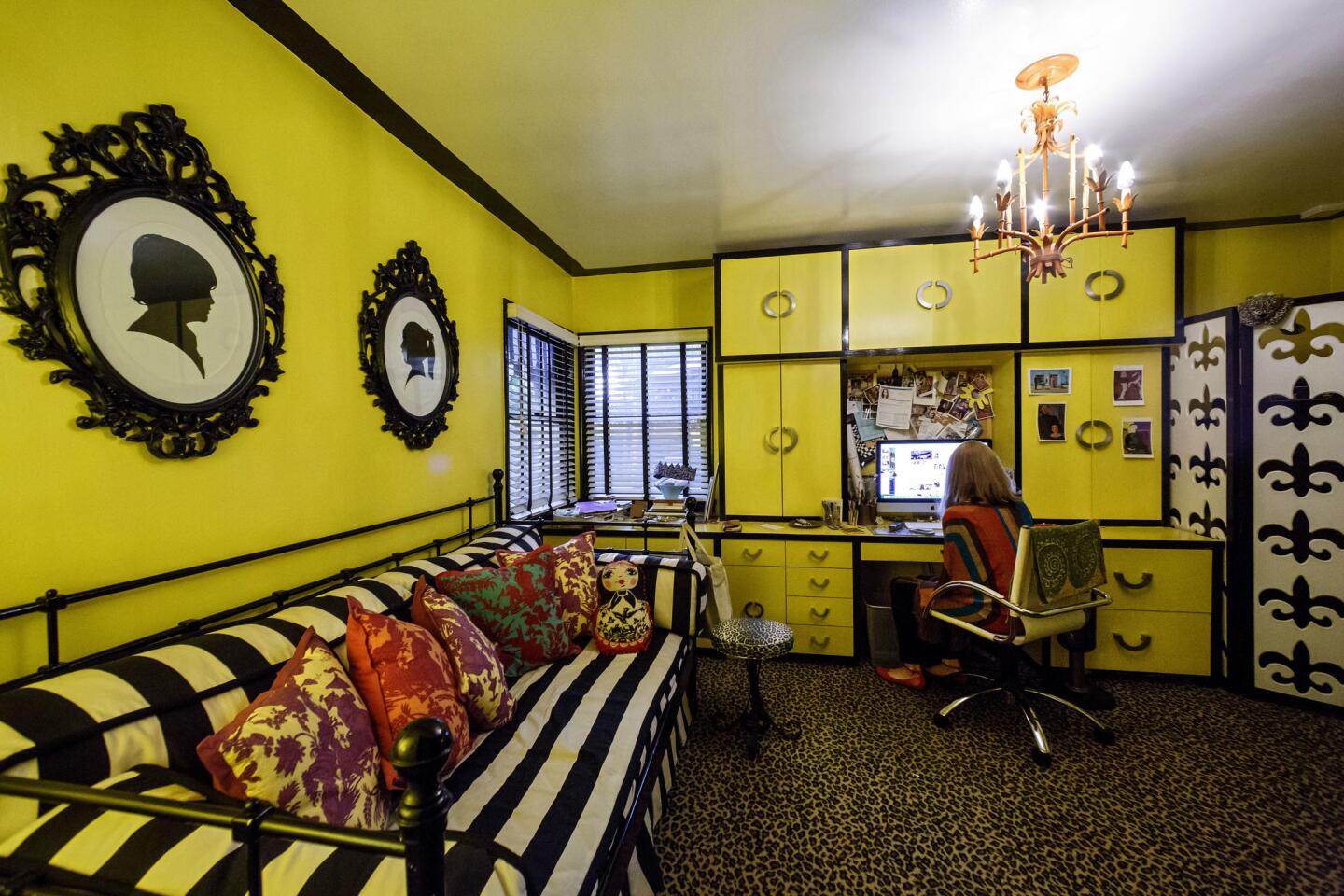 The maximalist theme prevails in Johanna McElfresh's office which she describes as her "ode to Kelly Wearstler." Here, bright yellow lacquered custom cabinets and walls mix with a leopard print rug, black and white striped daybed and coral-colored chandelier. The frames, at left, are from Ikea. Full house tour here.