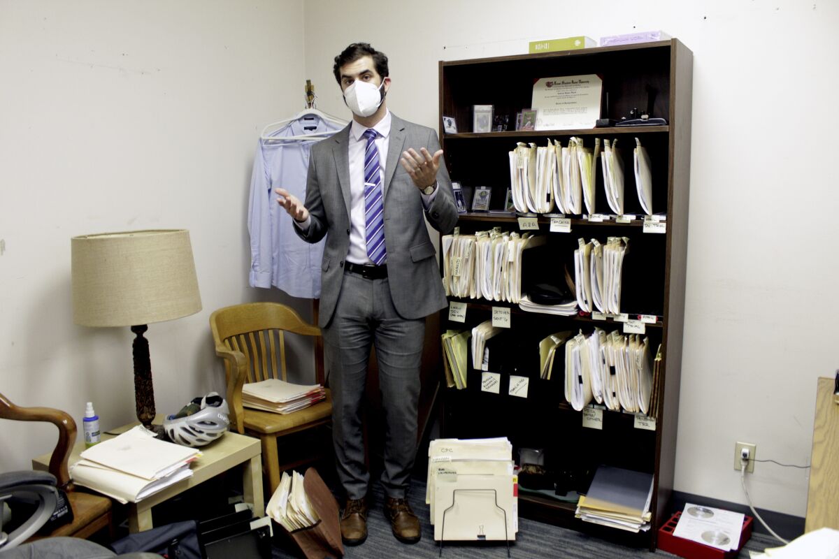 FILE - Public defender Drew Flood with the nonprofit law firm Metropolitan Public Defender looks his files for the criminal cases he is currently working on in Portland, Ore., on May 5, 2022. (AP Photo/Gillian Flaccus, File)