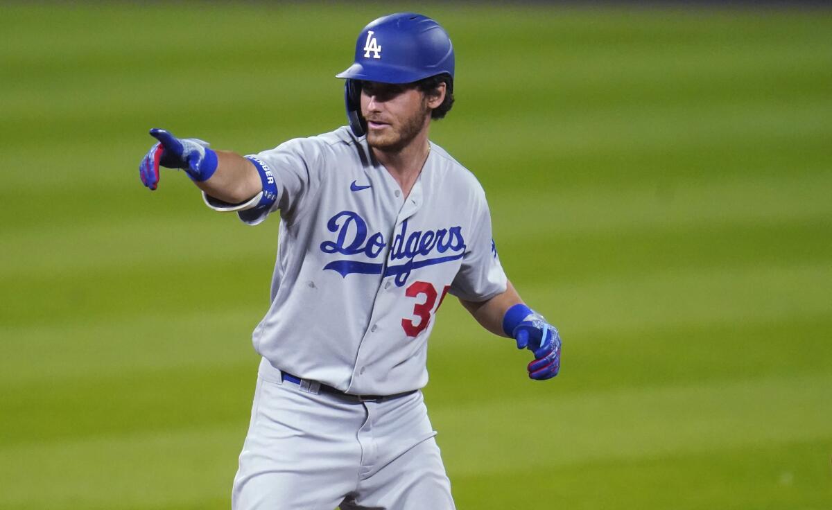 Dodgers' Cody Bellinger gestures to the dugout after pulling into second base.