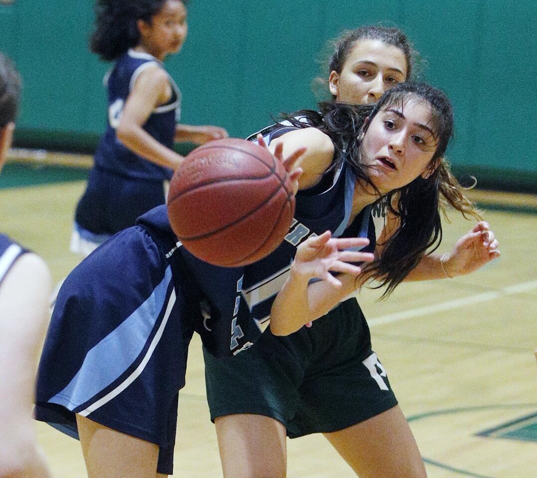 Crescenta Valley's Monique Arezoumanians passes off balance with Providence's Ella Shenouda defending in a summer league basketball game at Providence High School in Burbank on Thursday, June 13, 2019.