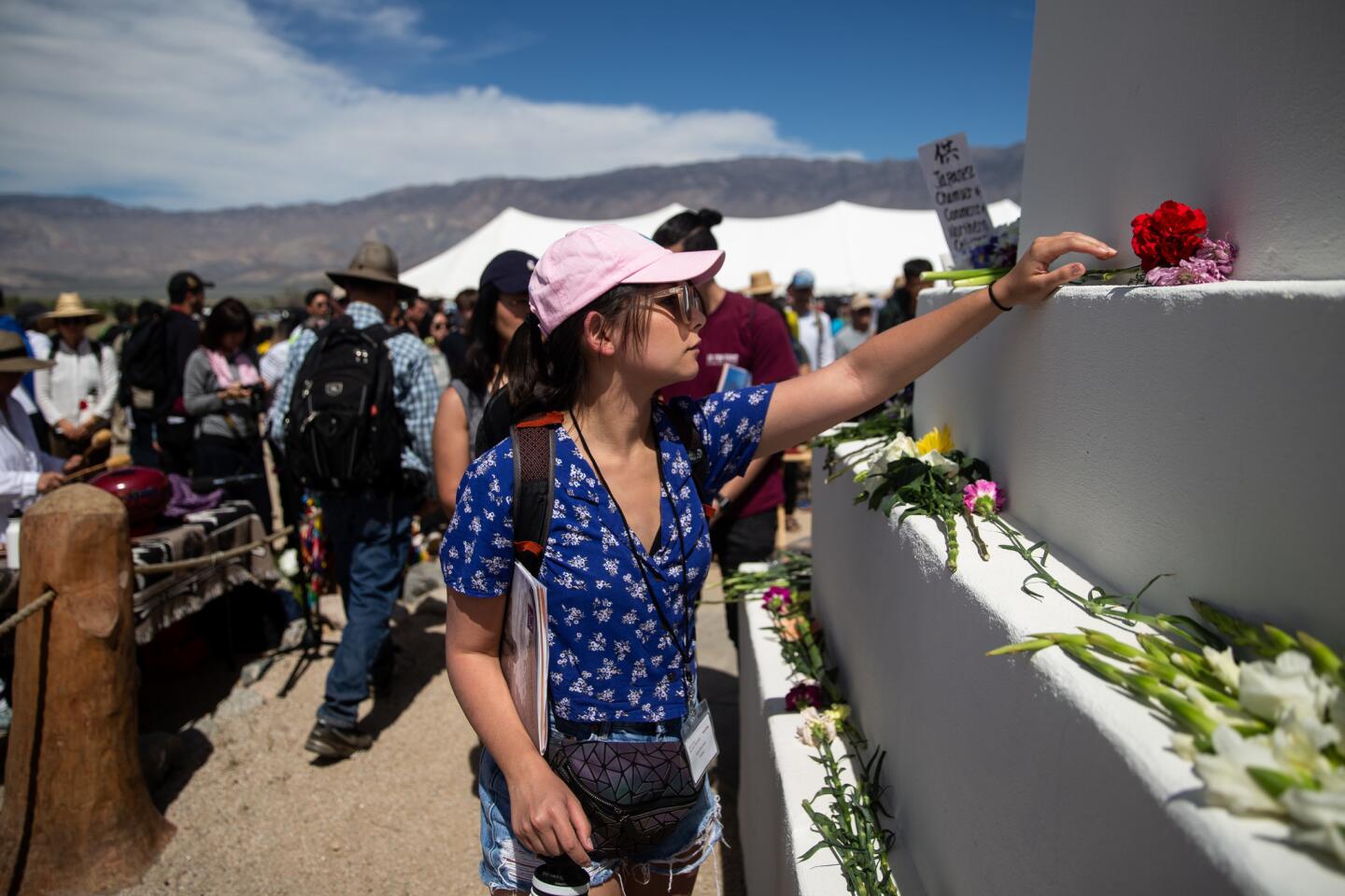 Alana Mouchard, 24, of Irvine, places a flower on a cemetery monument during the annual Manzanar Pilgrimage at the Manzanar National Historic Site.