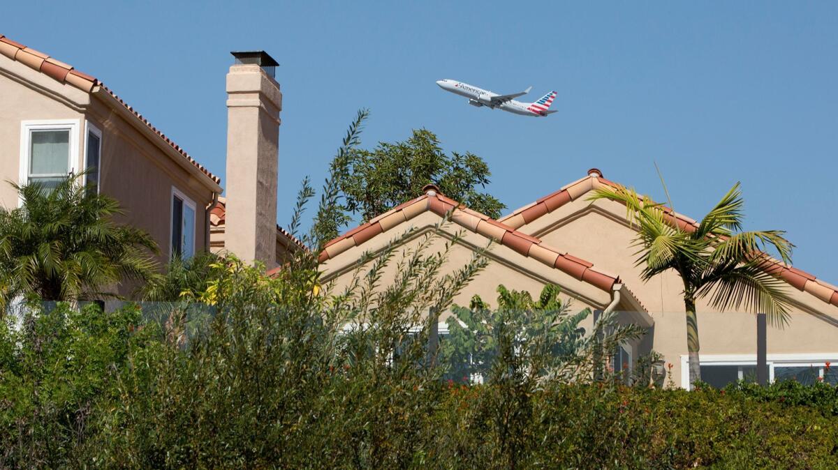 A commercial airplane flies over homes along Upper Newport Bay in Newport Beach after taking off from John Wayne Airport on Sept. 26.