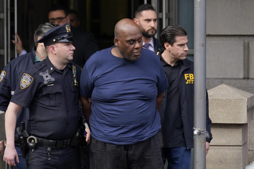 New York City Police, left, and law enforcement officials lead subway shooting suspect Frank R. James, 62, center, away from a police station, in New York, Wednesday, April 13, 2022. The man accused of shooting multiple people on a Brooklyn subway train was arrested Wednesday and charged with a federal terrorism offense after a daylong manhunt and a tipster's call brought police to him on a Manhattan street. (AP Photo/Seth Wenig)