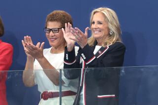 L.A. mayor Karen Bass, left, and First Lady Jill Biden clap before a women's water polo match on July 24.