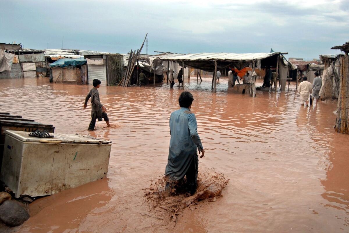 People gather around what is left of their shops after the floods swept through on the outskirts of Peshawar. (Arshad Arbab / European Pressphoto Agency)