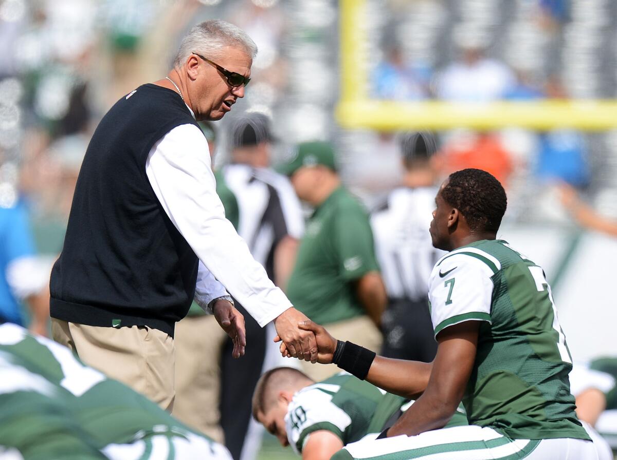 New York Jets Coach Rex Ryan shakes hands with quarterback Geno Smith before their game Sunday against the Detroit Lions at MetLife Stadium.