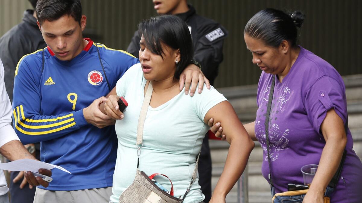 Barbara Barca, a survivor of the stampede at a crowded nightclub, is helped by relatives as they leave police headquarters in Caracas, Venezuela.