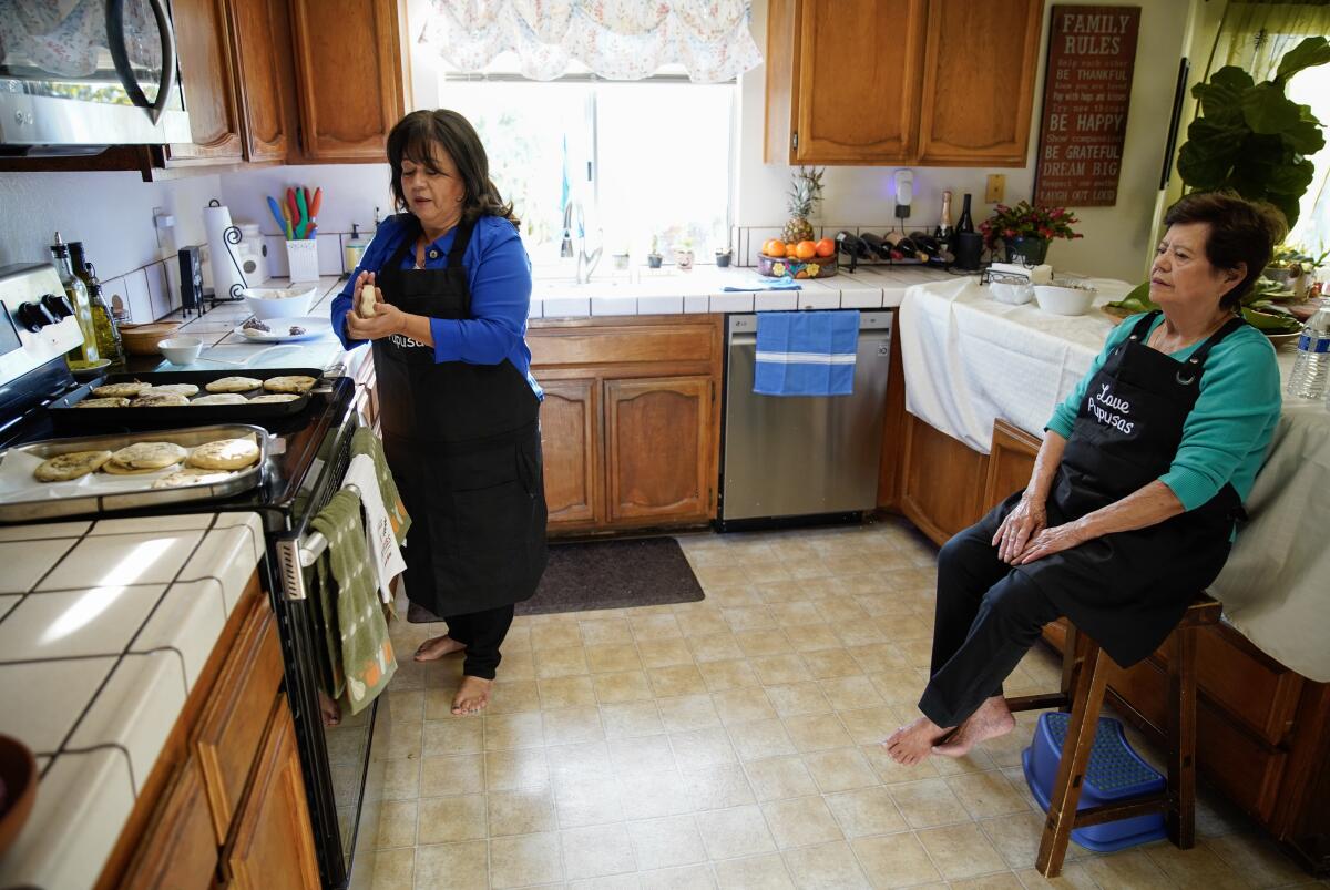 Yanira Majano makes pupusas using old family Salvadorian recipes while her 85-year-old mother Martha Martinez looks over