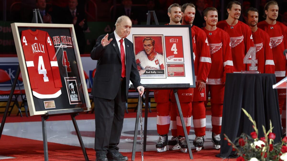 Former Detroit Red Wings player Red Kelly waves during his jersey retirement ceremony.