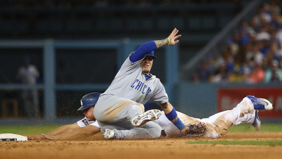 Corey Seager slides past Cubs second baseman Javier Baez on a steal attempt.